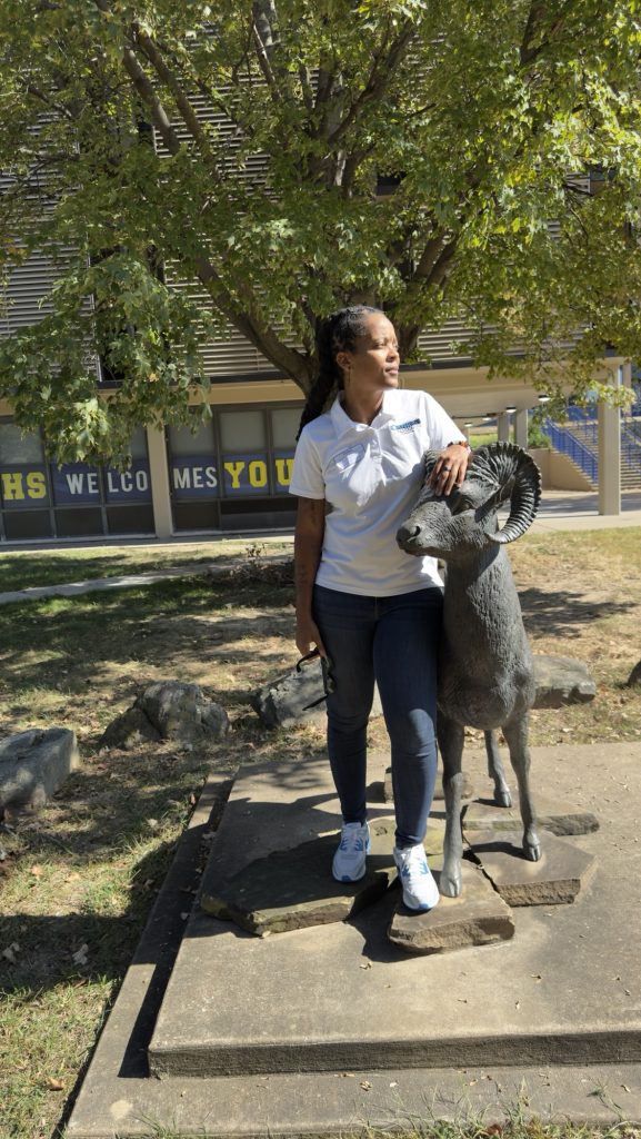 Mahogany Henderson, founder of Most Precious Dreams Foundation, standing beside the Riverview Rams statue at Riverview Gardens High School in St. Louis, Missouri.